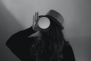 Black and white photo of a person looking through hazy glass ball